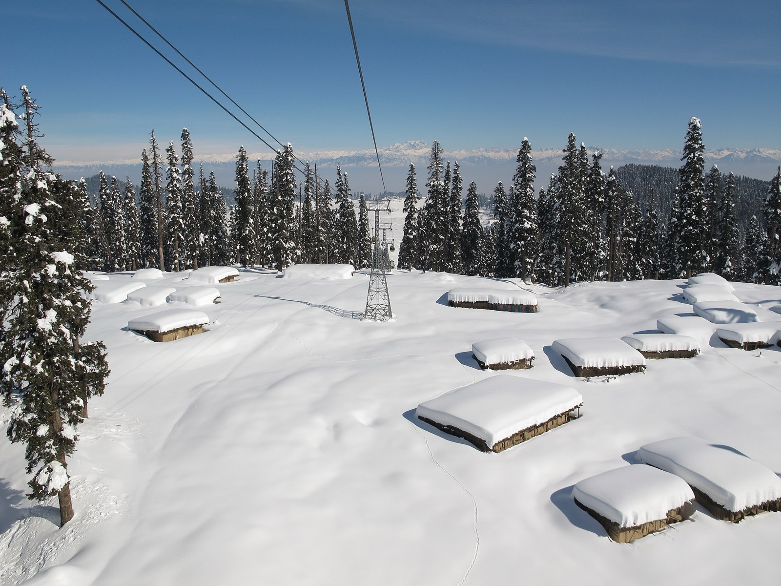 The Gulmarg Gondola cable car rising over snow-covered slopes