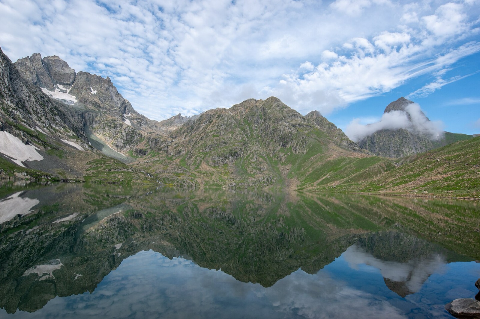 Turquoise Vishansar alpine lake surrounded by mountains on the Kashmir Great Lakes trek